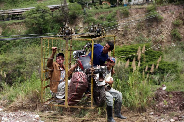 Productos agrícolas y motocicletas son trasladados por el carreto habilitado por los habitantes de la aldea Santa Clara desde que se cayó el puente. Fotos: Carlos Eduardo Ramírez