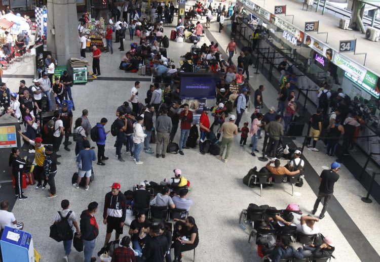 Migrantes venezolanos hacen fila para comprar sus boletos hacia el municipio de Necoclí, el viernes 7 de octubre de 2022, en la Terminal del Norte de Medellín (Colombia). EFE/ Luis Eduardo Noriega A.