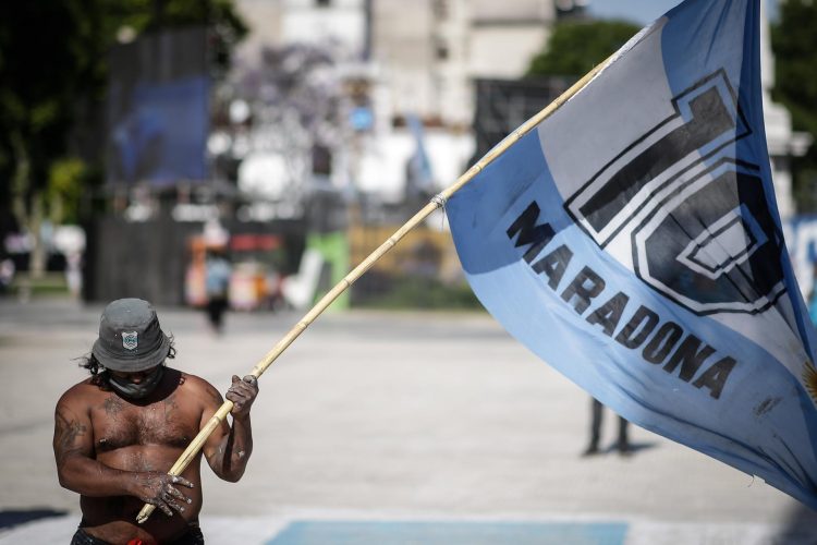 Un seguidor de Diego Armando Maradona con una bandera a las puertas de la Casa Rosada, en una fotografía de archivo. EFE/Juan Ignacio Roncoroni