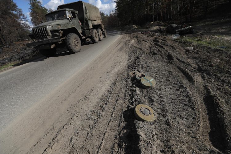 Vehículos militares ucranianos pasan por las minas que están al lado de la carretera que conduce a la aldea de Pesky-Radkivski, a unos 150 kilómetros al este de Jarkov, en Ucrania, el pasado 7 de octubre. EFE/EPA/ATEF SAFADI