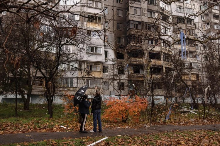 Ucranianos delante de un edificio dañado por bombas rusas en Jersón. EFE/EPA/ROMAN PILIPEY