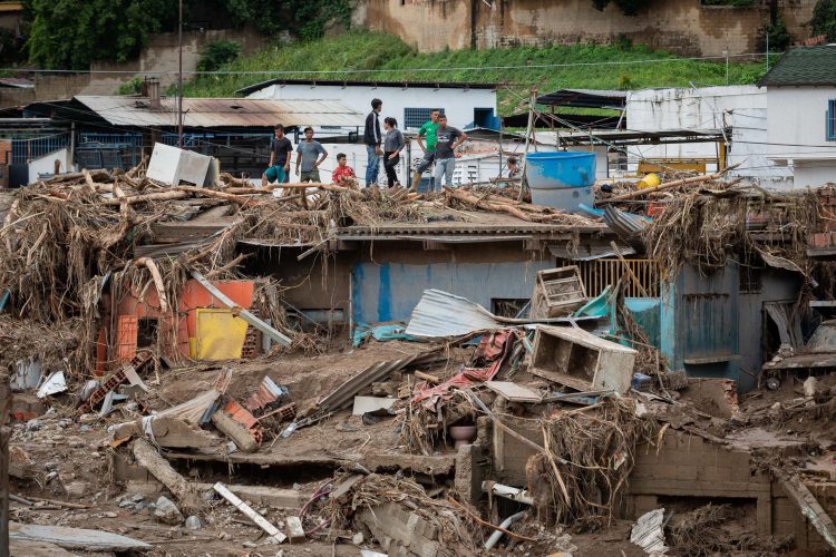 Fotografía de archivo, tomada el pasado 17 de octubre, en la que se registró a un grupo de personas al levantar los escombros que dejaron las lluvias y el desbordamiento de la quebrada Los Patos, en Las Tejerias (Venezuela). EFE/Rayner Peña