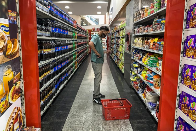 Fotografía de archivo de un hombre que revisa su celular mientras compra víveres en un supermercado en Caracas (Venezuela). EFE/ Miguel Gutiérrez