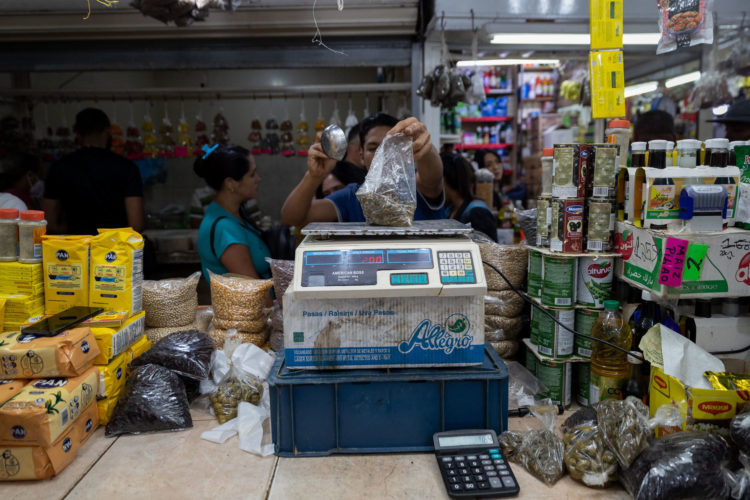 Un hombre vende parte de los ingredientes que se utilizan para la elaboración de las hallacas (plano navideño venezolano), en el mercado del bulevar de Catia, hoy en Caracas (Venezuela). EFE/ Rayner Peña R.
