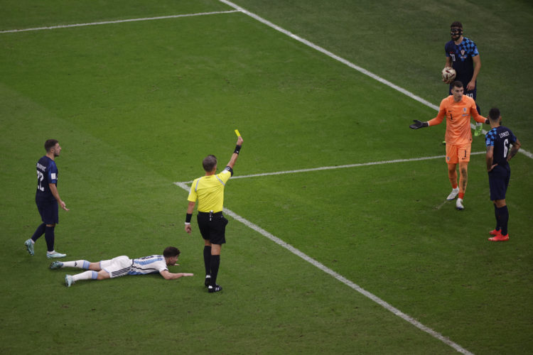 El árbitro italiano Daniele Orsato muestra tarjeta amarilla al meta croata Dominik Livakovic tras señalar penalti a favor de Argentina. EFE/ Alberto Estevez