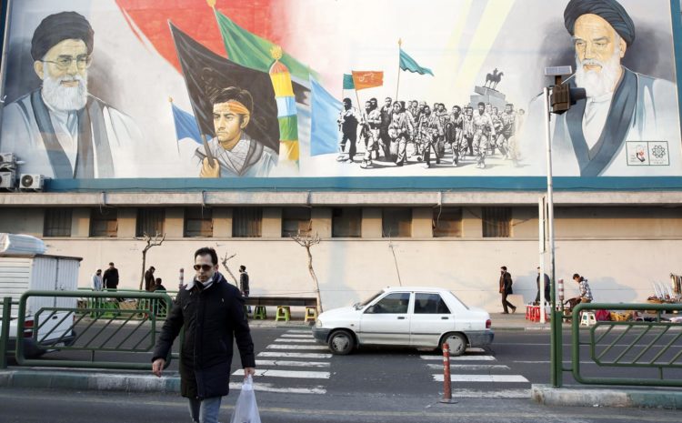 Un hombre iraní cruza una calle frente a un mural que representa al líder supremo iraní, el ayatolá Ali Jamenei (arriba-izq) y al exlíder supremo iraní, el ayatolá Ruhollah Jomeini (arriba -der) en Teherán el 17 de febrero de 2022 EFE/EPA/ABEDIN TAHERKENAREH