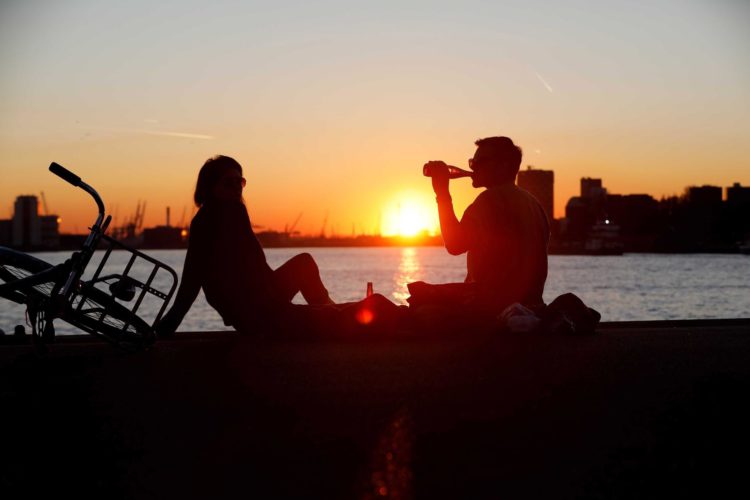 En la imagen de archivo, dos personas beben una cerveza en un muelle frente a la puesta de sol. EFE/ Bas Czerwinski