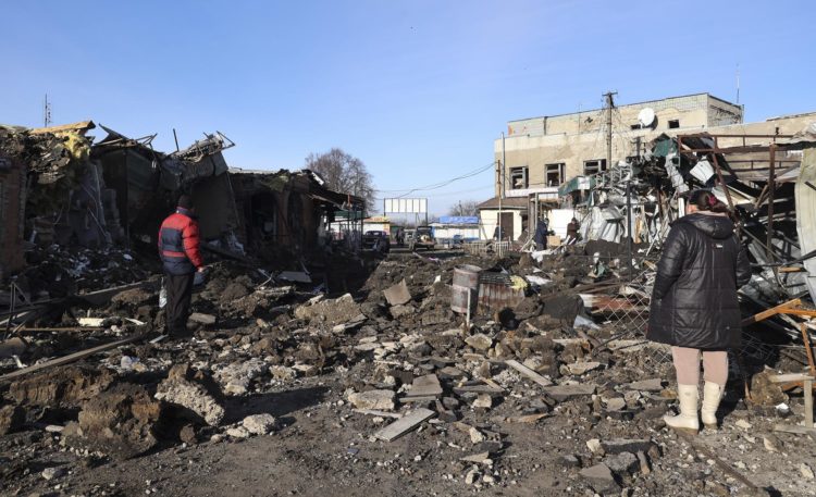 Dos ucranianos se encuentran entre los escombros en un mercado local dañado por los bombardeos rusos en la ciudad de Shevchenkove, en Ucrania, este 9 de enero . EFE/EPA/SERGEY KOZLOV