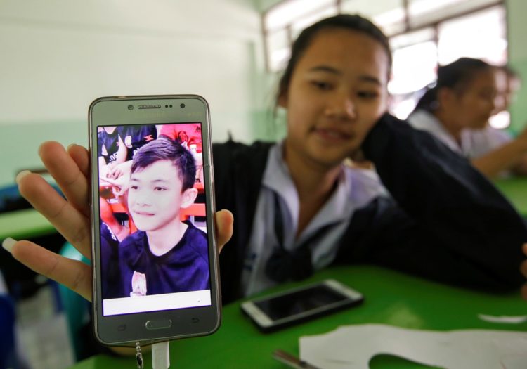 Una estudiante tailandesa muestra una imagen de su compañero Duangpetch Promthep durante el período en el que estuvo atrapado en una cueva con otros adolescentes. EPA/RUNGROJ YONGRIT