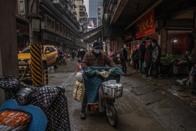 Un hombre con mascarilla protectora pasa por un mercado de una zona residencial de Wuhan, China, el 22 de enero de 2021. EFE/EPA/PILIPEY ROMANO