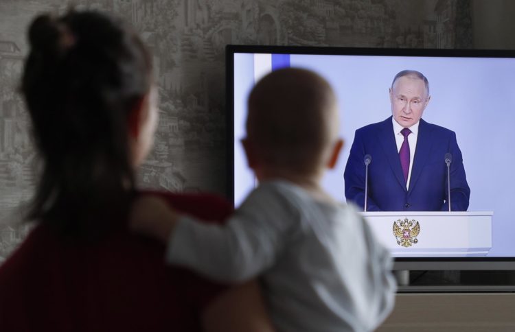 Una mujer ve desde su casa el discurso del presidente ruso, Vladímir Putin. EFE/EPA/MAXIM SHIPENKOV