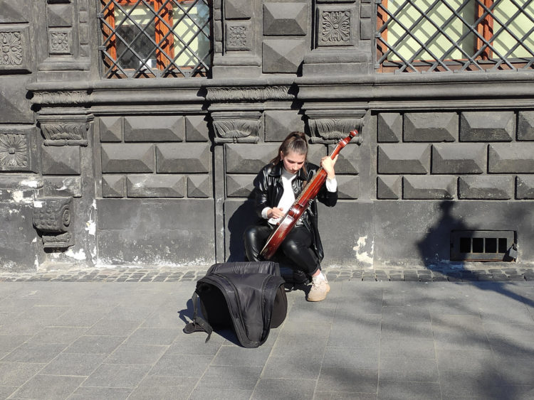 Una mujer toca la kobza, un instrumento tradicional ucraniano, en una calle de la ciudad ucraniana de Leópolis. Durante el año de invasión rusa la música ha alentado a los ucranianos a resistir. EFE/ Rostyslav Averchuk