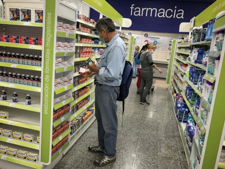 Fotografía de archivo en la que se registró a un par de compradores al detallar los aparadores del interior de una farmacia en Caracas (Venezuela). EFE/Rayner Peña