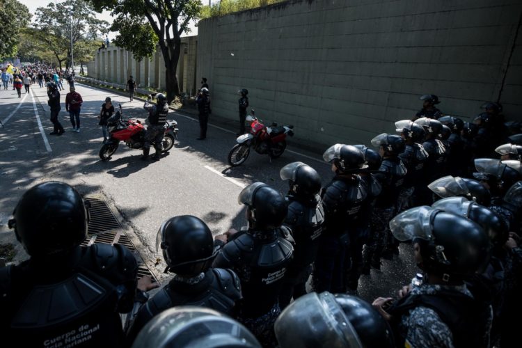 Policías vigilan mientras trabajadores del sector publico se manifiestan en Caracas (Venezuela). EFE/MIGUEL GUTIÉRREZ