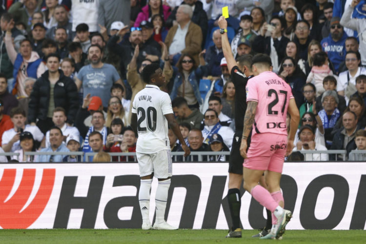 El delantero brasileño del Real Madrid, Vinicius Jr (i) ve la tarjeta amarilla durante el partido de LaLiga entre Real Madrid y RCD Espanyol disputado en el Santiago Bernabéu en Madrid. EFE/Rodrigo Jiménez