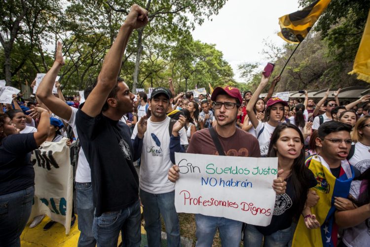 Fotografía de archivo en la que se registro a un grupo de estudiantes y profesores universitarios al marchar para exigir un aumento de salario, en Caracas (Venezuela). EFE/Miguel Gutiérrez