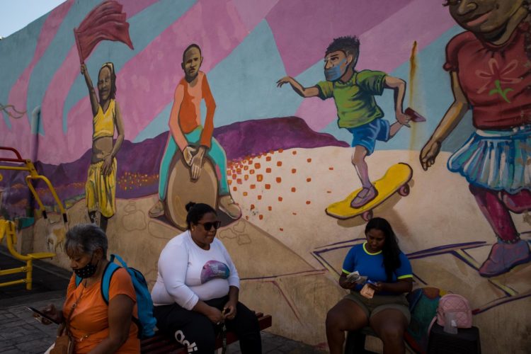 Mujeres son vistas frente a un mural sobre afrodescendientes, el 16 de marzo de 2023 en Caracas (Venezuela). EFE/Miguel Gutiérrez