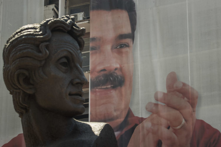 Detalle de una estatua de Simón Bolívar frente a una imagen del presidente de Venezuela, Nicolás Maduro, en Caracas (Venezuela). EFE/Miguel Gutierrez