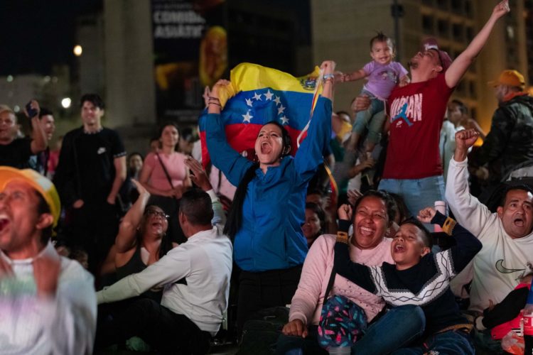 Grupos de personas reaccionan mientras observan una transmisión del partido entre Estados Unidos y Venezuela durante los cuartos de final del Clásico Mundial de Beísbol hoy, en Caracas (Venezuela). EFE/ Rayner Peña R.