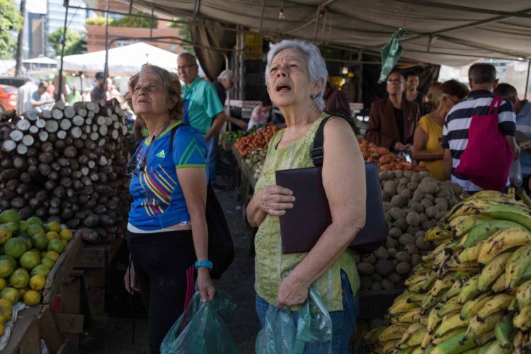 Fotografía de archivo en al que se registró a un par de mujeres al mercar, en una plaza de hortalizas y verduras, en Caracas (Venezuela). EFE/Christian Hernández