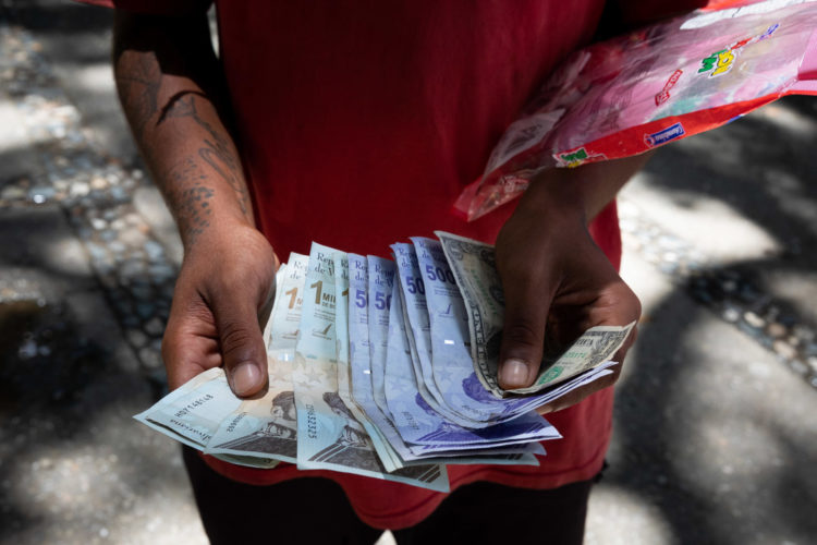 Un vendedor ambulante muestra billetes de bolívar, en Caracas (Venezuela). EFE/ Rayner Peña R.