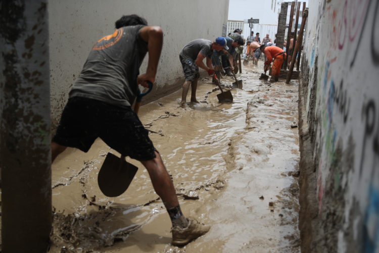 Personas ayudan a remover el lodo en una calle afectada por las lluvias en Lima (Perú). Foto de archivo. EFE/ Paolo Aguilar