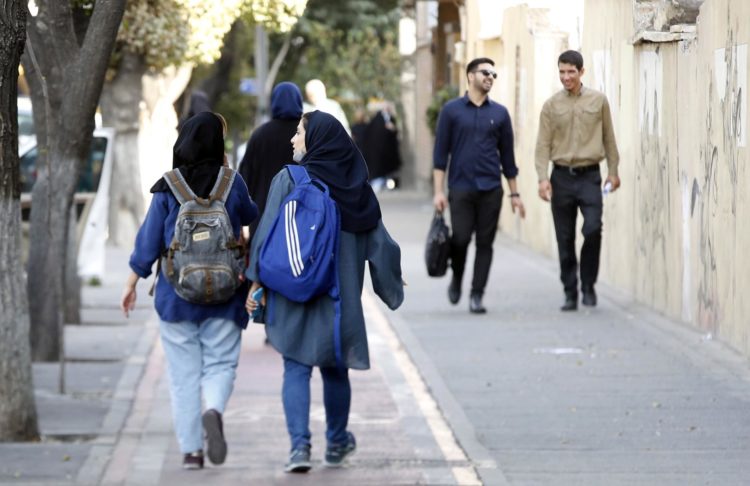 Jóvenes iraníes con pañuelo en la cabeza en una calle de Teherán en octubre de 2022. EFE/EPA/ABEDIN TAHERKENAREH