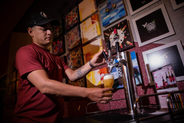 Un hombre sirve una cerveza artesanal en Caracas (Venezuela). EFE/ Rayner Peña R.