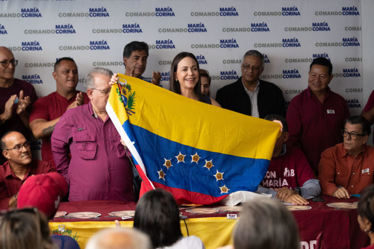 La opositora María Corina Machado (c), sostiene una bandera de Venezuela hoy, durante un evento junto a miembros del partido Alianza Bravo Pueblo (ABP), en Caracas (Venezuela). EFE/Rayner Peña R.