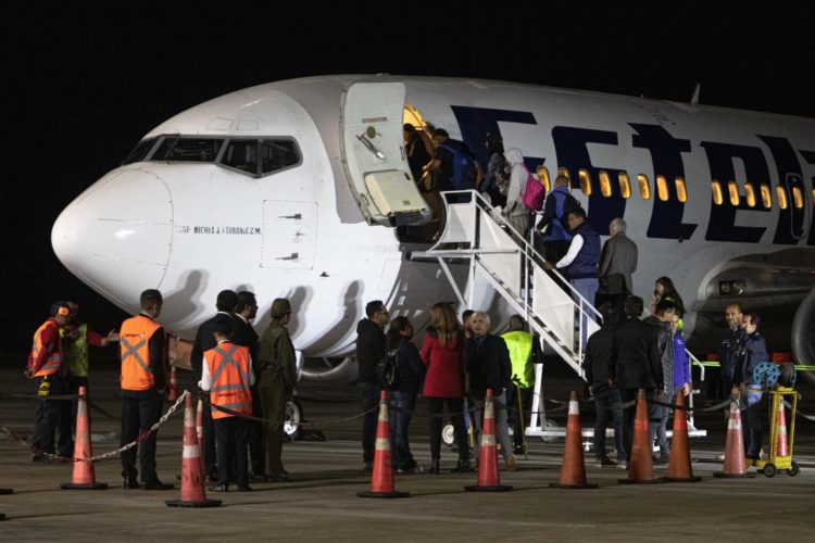 Migrantes abordan un avión de la aerolínea Estelar con destino a Venezuela, hoy, en el aeropuerto Internacional Chacalluta de Arica (Chile). EFE/ Lucas Aguayo Araos