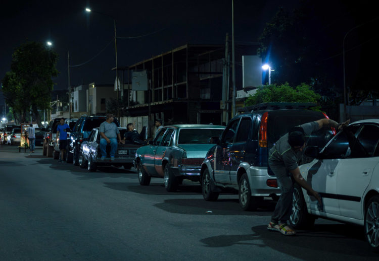 Un grupo de hombres pernoctan en una fila junto a sus vehículos mientras esperan para surtir combustible, 13 de junio de 2023, en Maracaibo (Venezuela). EFE/ Henry Chirinos