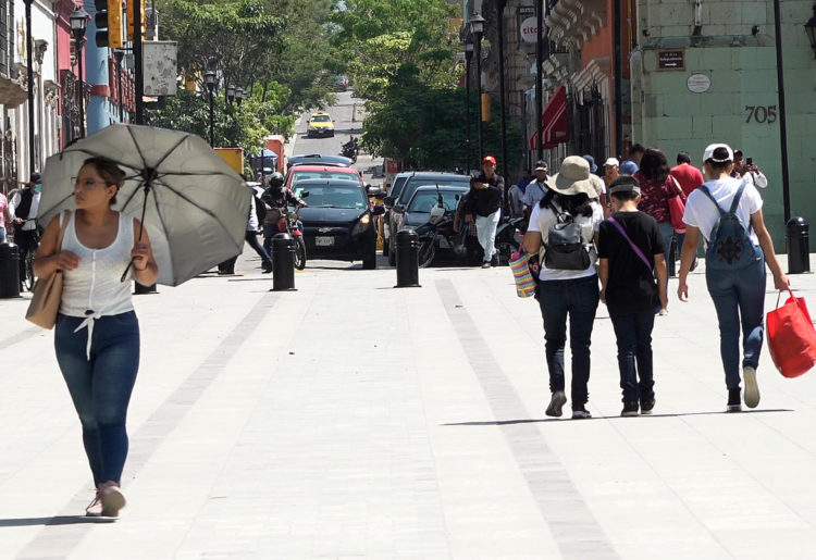 Personas se protegen del sol el 13 de junio de 2023, debido a las altas temperaturas registradas en el estado de Oaxaca (México). EFE/Jesús Méndez