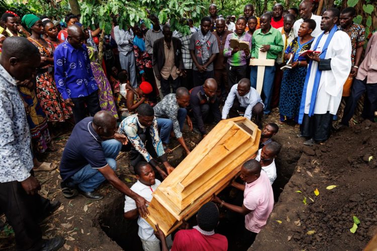 Personas bajan un ataúd a una tumba durante el funeral de una de las víctimas de un ataque en una escuela, en Mpondwe, Uganda, este 18 de junio de 2023. EFE/EPA/Luke Dray
