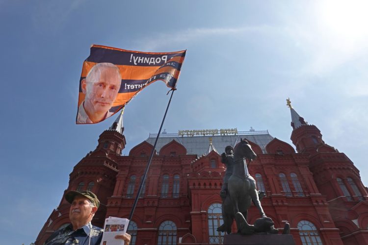 Un integrante del Movimiento de Liberación Nacional sostiene en Moscú una bandera de apoyo al presidente ruso, Vladímir Putin, cerca del Kremlin. EFE/EPA/Maxim Shipenkov