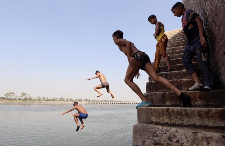 En la imagen de ayer, varios niños se lanzan al agua del Nilo para refrescarse, en Qanater, en las afueras de El Cairo. EFE/KHALED ELFIQI