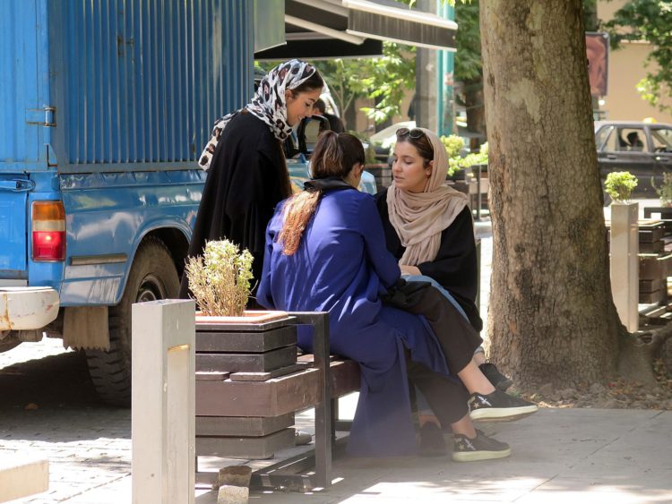Imagen de archivo de tres jóvenes, una de ellas con el velo caído, charlando en una calle del norte de Teherán. EFE/ Marina Villén