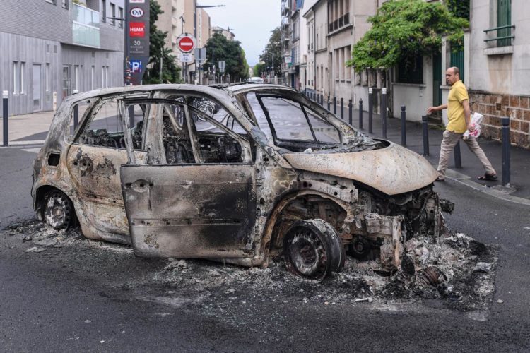 Montreuil (Francia), 01/07/2023.- Una persona se acerca a los restos de un coche quemado en Montreuil, cercano a París EFE/EPA/JULIEN MATTIA