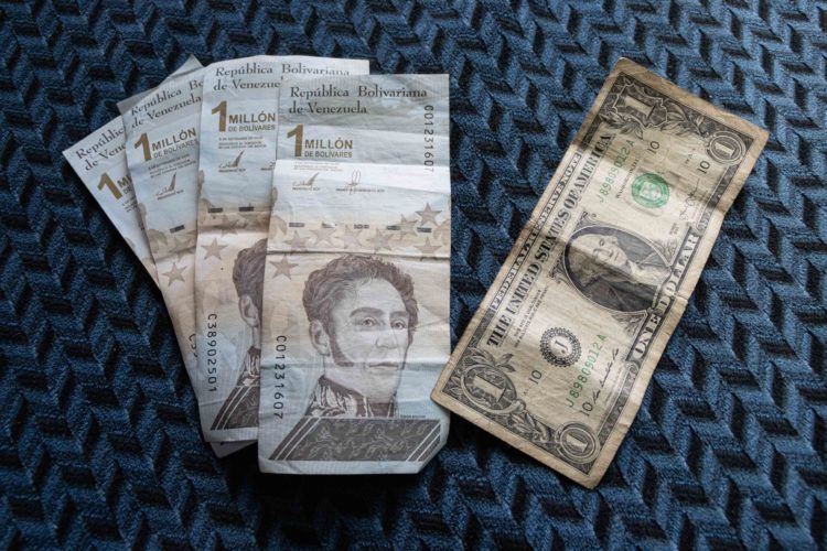 Fotografía que muestra cuatro billetes de un millón de bolívares junto a su equivalente de un dolar, en una fotografía de archivo. EFE/ Ronald Peña