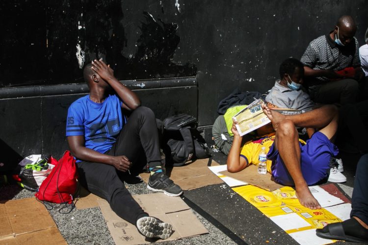 Migrantes permanecen sentados a las afueras de un hotel de Nueva York, el 1 de agosto de 2023. EFE/Sarah Yenesel