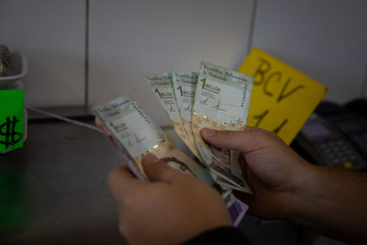 Un vendedor cuenta billetes de un millón de bolívares, en una fotografía de arcivo. EFE/ Rayner Peña R.