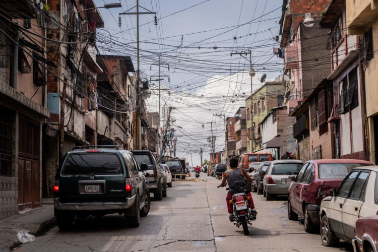 Un motociclista pasa por una calle con múltiples conexiones de cableado eléctrico, el 8 de septiembre de 2023, en Caracas (Venezuela). EFE/ Rayner Pena R