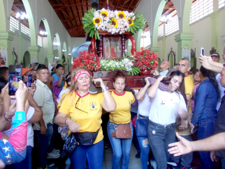A la salía del templo San Juan Bautista las damas cargadoras llevan en sus hombros a San Benito.