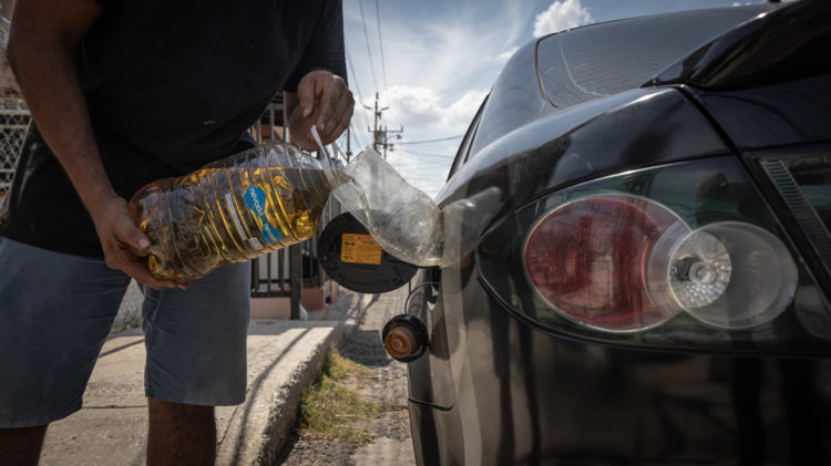 Un vendedor informal fue registrado, el pasado 29 de septiembre, al suministrar gasolina de contrabando a un vehículo, en Maracaibo (Venezuela). EFE/Henry Chirinos