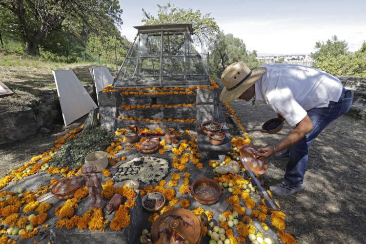 Un hombre adorna el Altar de los cráneos esculpidos con maíz, amaranto, cacao y flores de cempasúchil, el 1 de noviembre de 2023, en la zona arqueológica de Cholula, estado de Puebla (México). EFE/Hilda Ríos