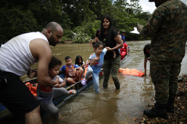 Fotografías de migrantes bajan de canoas para ser trasladados a una estación de recepción migratoria en Lajas Blancas, Metetí, Darién (Panamá). EFE/ Bienvenido Velasco