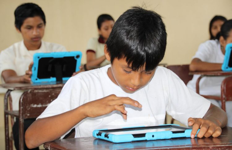Fotografía de archivo en la que se registró a un grupo de niños ecuatorianos al revisar información en línea en sus tabletas digitales escolares, en Orellana (Ecuador). EFE/Elías Benarroch