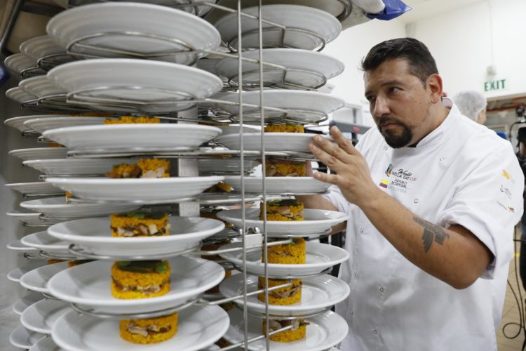 El chef colombiano Arturo Pedregal apila platos de paella el 16 de noviembre de 2023, en Bogotá (Colombia). EFE/ Carlos Ortega