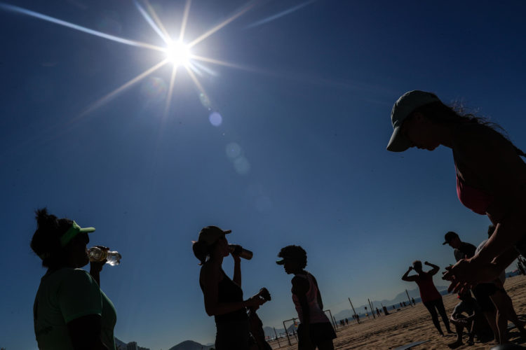 Imagen de archivo de un grupo de personas mientras beben agua durante el descanso de una actividad física en una playa en una jornada calurosa. EFE/André Coelho