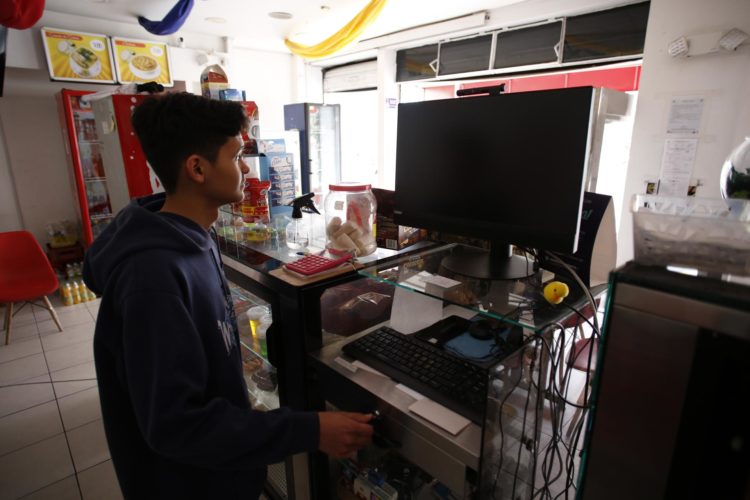 Un joven trabaja en una tienda donde no hay energía en Quito (Ecuador). Foto de archivo. EFE/ Santiago Fernández