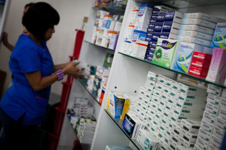 Una trabajadora de una farmacia, acomoda los estantes de medicinas, en Caracas, en una fotografía de archivo. EFE/MIGUEL GUTIERREZEFE/